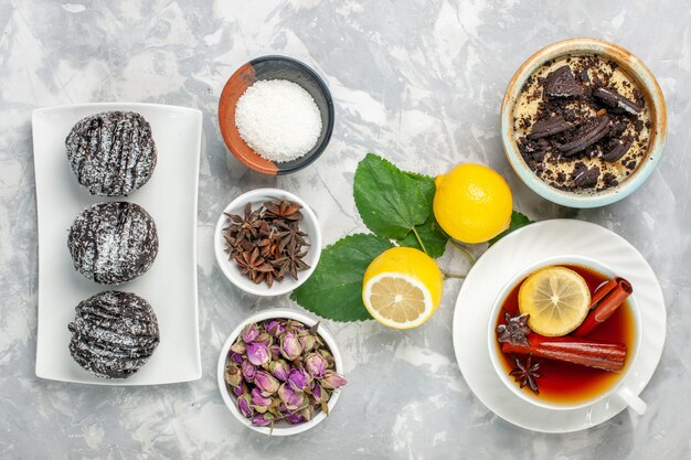 Vista superior delicioso postre cremoso de galleta con taza de té y limón sobre superficie blanca galleta de fruta pastel dulce de azúcar