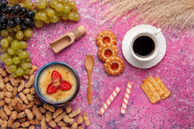Vista superior delicioso postre cremoso con galletas de uvas frescas y cacahuetes en la superficie rosa claro postre helado baya crema fruta dulce