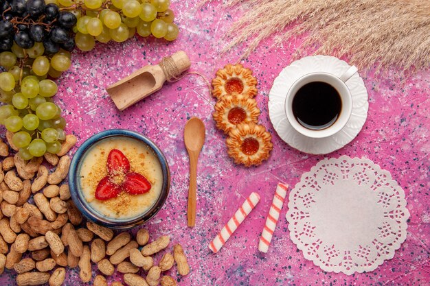 Vista superior delicioso postre cremoso con galletas de uvas frescas y cacahuetes en la superficie rosa claro postre helado baya crema fruta dulce