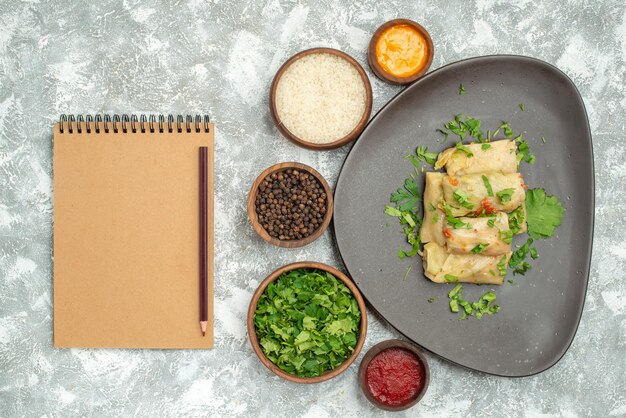 Vista superior del delicioso repollo dolma consiste en carne molida con verduras sobre fondo blanco plato de carne cena calorías aceite comida