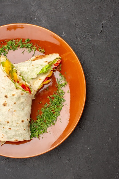 Vista superior delicioso sándwich de ensalada shaurma en rodajas con rodajas de limón dentro de la placa sobre fondo oscuro hamburguesas comida bocadillo pan