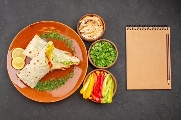 Vista superior delicioso sándwich de ensalada shaurma en rodajas con verduras en el fondo oscuro bocadillo de pan sándwich de comida de hamburguesa