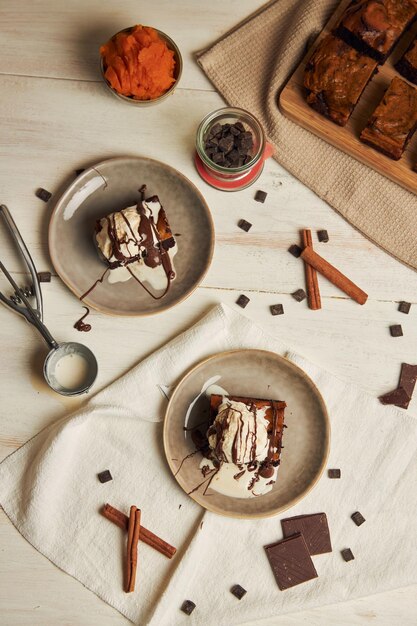 Vista superior de deliciosos brownies de chocolate con calabaza recién horneados con helado en un plato