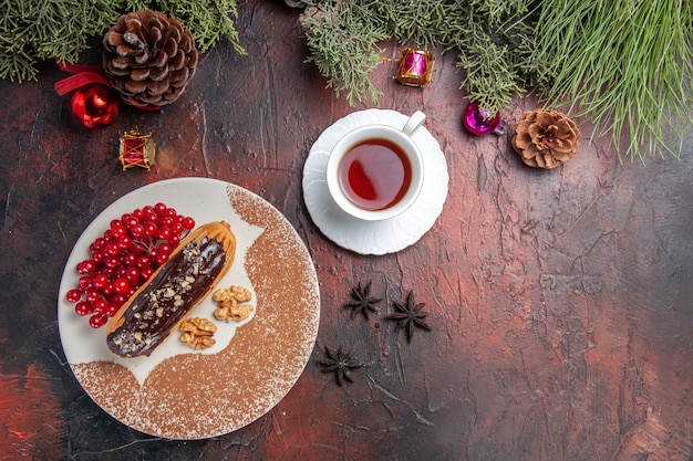 Vista superior deliciosos canutillos de chocolate con bayas y té en la mesa oscura pastel postre dulce