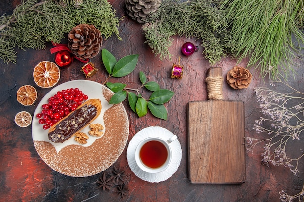 Vista superior deliciosos canutillos de chocolate con té y bayas en el postre de pastel dulce pastel de mesa oscura