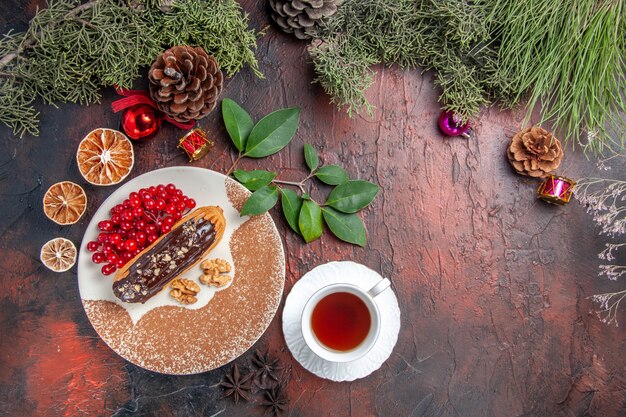 Vista superior deliciosos canutillos de chocolate con té y bayas en el postre de pastel de pastel dulce de mesa oscura