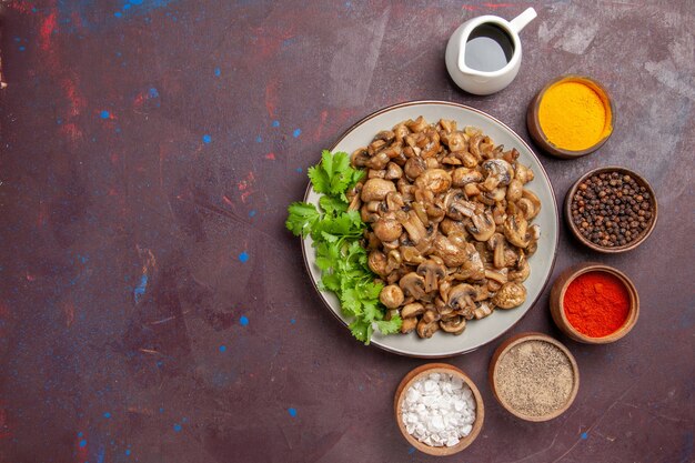 Vista superior deliciosos champiñones cocidos con verduras y condimentos en la oscuridad