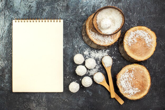 Foto gratuita vista superior deliciosos dulces de coco con piezas de madera sobre fondo oscuro té fruta color foto golosinas dulce