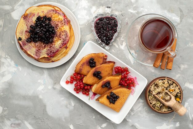 Una vista superior deliciosos panqueques deliciosos con gelatina de arándanos y pastelería de canela para cocinar