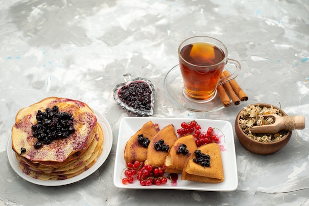 Una vista superior deliciosos panqueques deliciosos con té de arándanos gelatinosos y pasteles de panqueques de canela