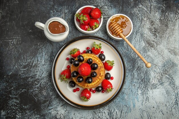 Vista superior deliciosos panqueques con frutas frescas en piso ligero pastel de frutas dulce