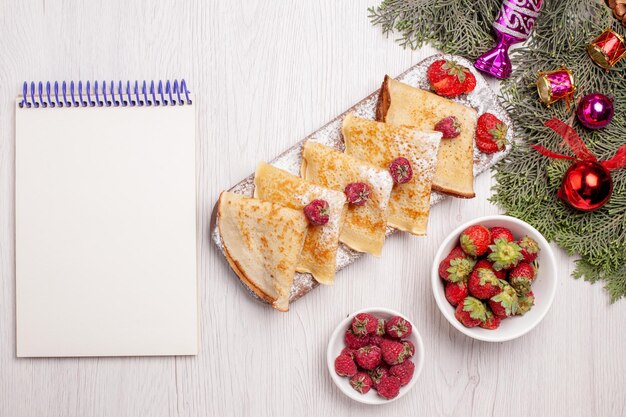 Vista superior deliciosos panqueques con frutas sobre fondo blanco pastel dulce postre panqueque de té de frutas