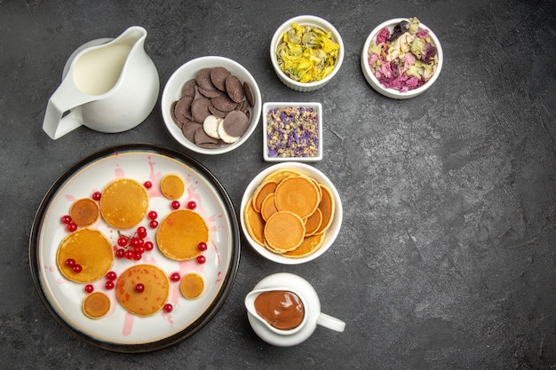 Vista superior deliciosos panqueques con galletas sobre fondo oscuro