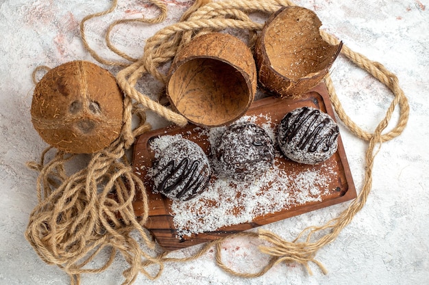 Vista superior deliciosos pasteles de chocolate con coco sobre superficie blanca