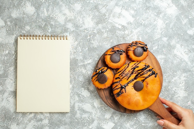 Foto gratuita vista superior deliciosos pasteles con chocolate y glaseado en la superficie blanca pastel pastel de galletas de cacao postre galleta dulce