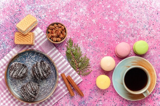 Vista superior deliciosos pasteles de chocolate con taza de té en el rosa