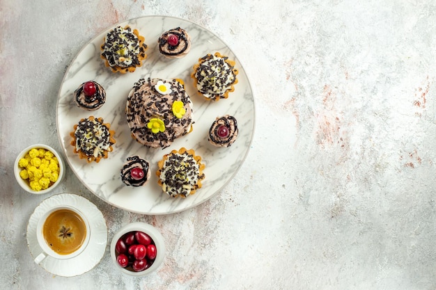 Foto gratuita vista superior deliciosos pasteles cremosos con pepitas de chocolate en la superficie blanca galleta de pastel de té crema de galleta de cumpleaños dulce