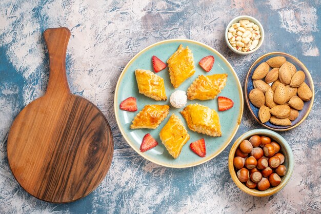 Vista superior deliciosos pasteles dulces con nueces sobre fondo azul.