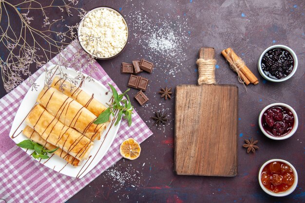 Vista superior deliciosos pasteles dulces con requesón y mermelada sobre fondo oscuro galleta galleta azúcar pastel dulce té