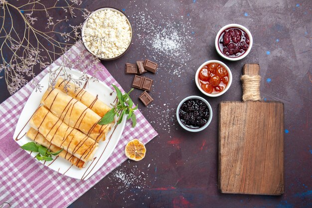 Vista superior deliciosos pasteles dulces con requesón y mermelada sobre fondo oscuro galleta galleta azúcar té dulce pastel