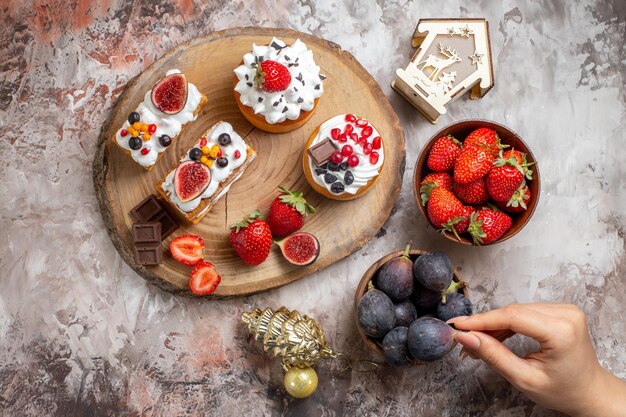 Vista superior de deliciosos pasteles con frutas frescas en el fondo claro