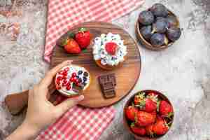 Foto gratuita vista superior de deliciosos pasteles con frutas frescas en el fondo claro