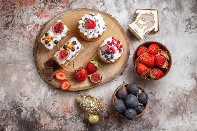 Vista superior de deliciosos pasteles con frutas frescas en el fondo claro