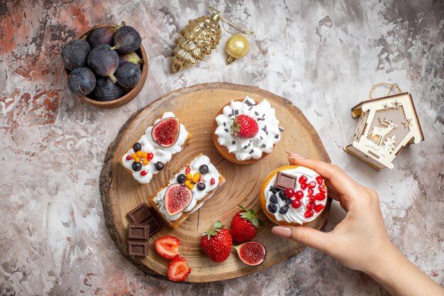 Vista superior de deliciosos pasteles con frutas frescas en el fondo claro