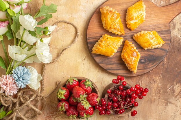 Vista superior de deliciosos pasteles de nueces con frutas en un escritorio de madera