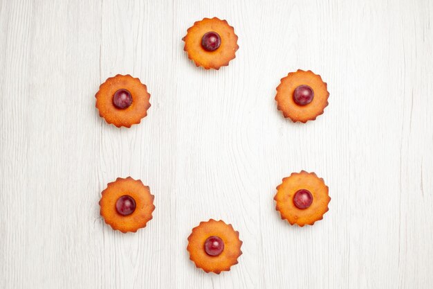 Foto gratuita vista superior deliciosos pasteles con uvas en mesa blanca postre galletas pastel de galletas