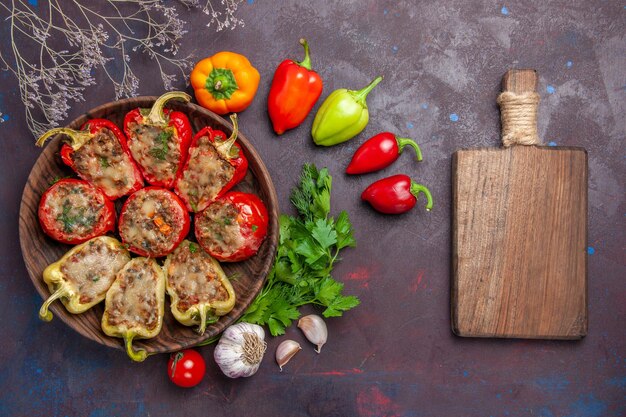 Vista superior deliciosos pimientos al horno plato con carne picada y verduras en el fondo oscuro cena comida hornear sal plato carne