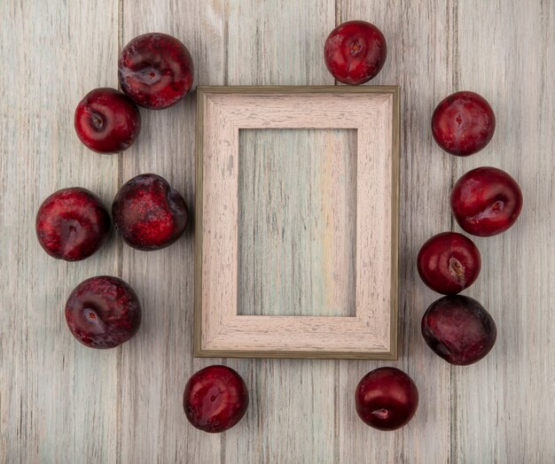 Vista superior de deliciosos pluots maduros aislados en una superficie de madera gris con espacio de copia