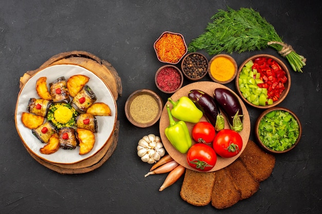 Vista superior deliciosos rollos de berenjena plato cocido con patatas y verduras en el fondo oscuro plato de comida para cocinar hornear patatas fritas