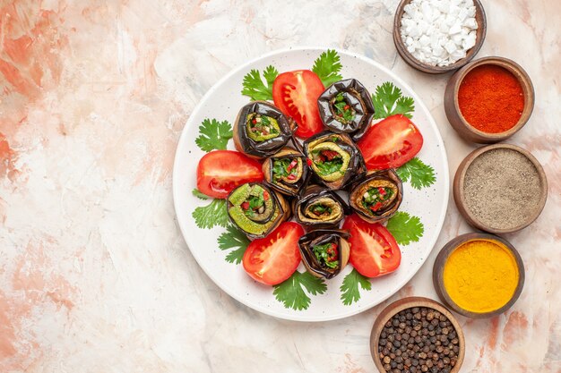 Vista superior deliciosos rollos de berenjena con verduras y tomates