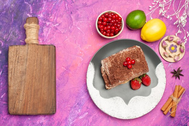 Vista superior de deliciosos rollos de galletas con frutas en el escritorio rosa