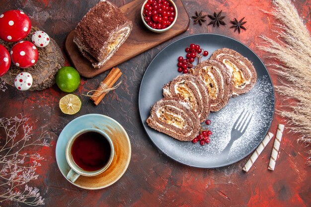 Vista superior de deliciosos rollos de galletas con una taza de té sobre fondo oscuro