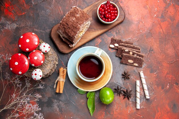 Vista superior de deliciosos rollos de galletas con una taza de té sobre fondo oscuro