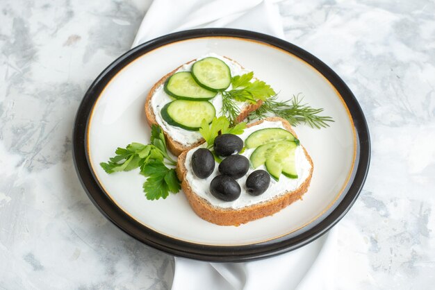 Vista superior deliciosos sándwiches con pepinos y aceitunas dentro del plato fondo blanco salud comida horizontal comida pan almuerzo tostadas hamburguesas