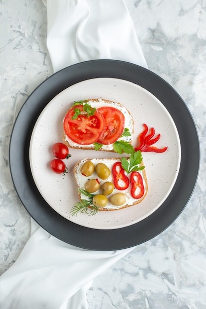 Foto gratuita vista superior deliciosos sándwiches con tomates y aceitunas dentro del plato fondo blanco tostadas pan almuerzo hamburguesa comida horizontal comida