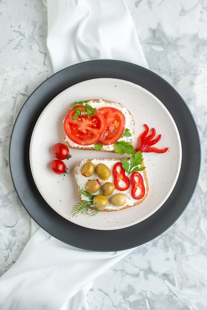 Vista superior deliciosos sándwiches con tomates y aceitunas dentro del plato fondo blanco tostadas pan almuerzo hamburguesa comida horizontal comida
