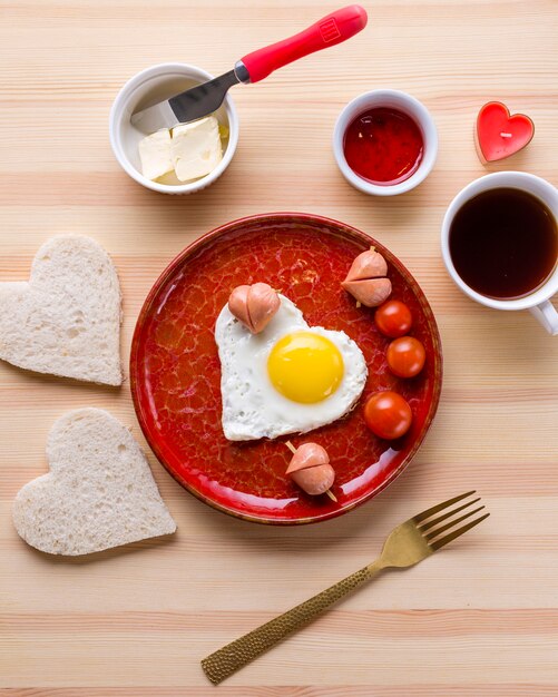 Vista superior del desayuno romántico y huevo en forma de corazón con tostadas