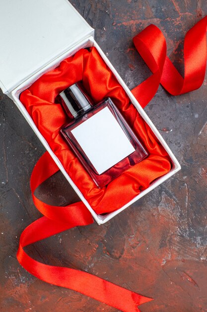 Vista superior del día de san valentín presente fragancia en la superficie oscura regalo perfume amor sentimiento color amante pareja felicidad mujer