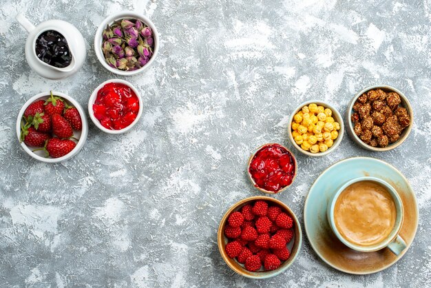 Vista superior de diferentes caramelos con frutos secos, frutas y café en el espacio en blanco