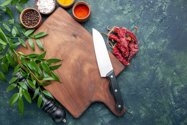 Vista superior de diferentes condimentos con escritorio de madera marrón sobre el fondo azul oscuro color madera afilados cubiertos árbol verde cocina