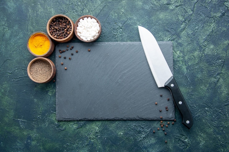 Foto gratuito vista superior de diferentes condimentos en la superficie azul oscuro alimentos especias sal pimienta colores fotográficos