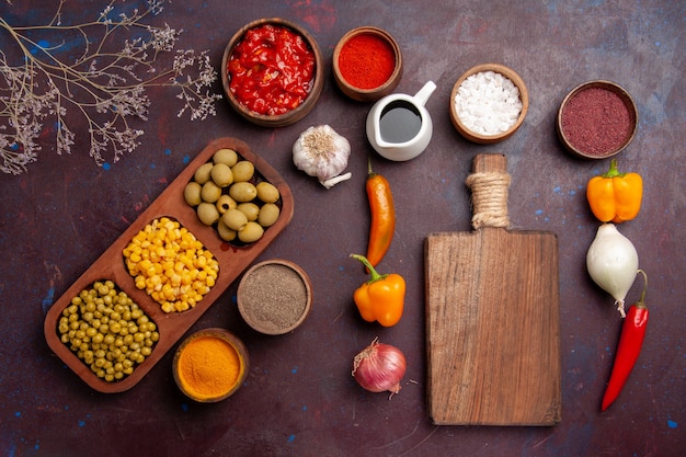 Foto gratuita vista superior de diferentes condimentos con verduras en el espacio oscuro.