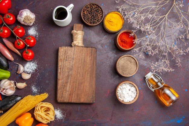 Vista superior de diferentes condimentos con verduras en el fondo oscuro ensalada de comida de pimiento picante salud