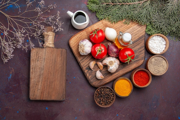 Vista superior de diferentes condimentos con verduras frescas en negro