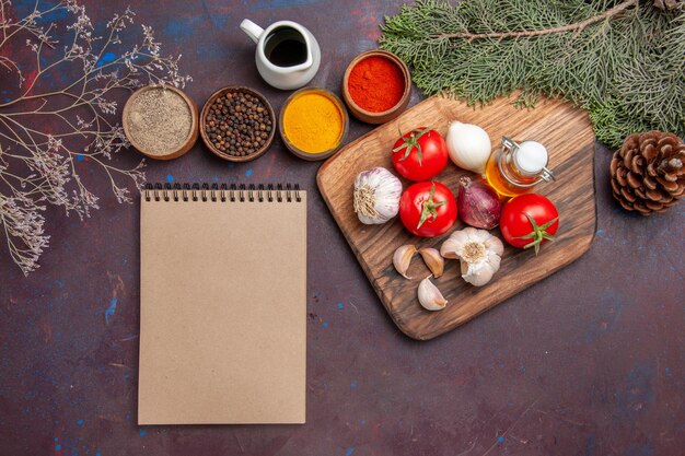 Vista superior de diferentes condimentos con verduras frescas en negro