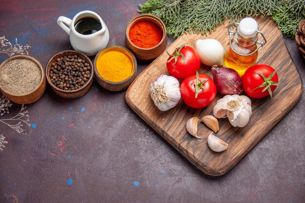 Vista superior de diferentes condimentos con verduras frescas en negro